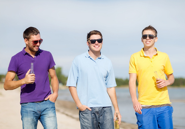 amis heureux boire de la bière et marcher sur la plage
 - Photo, image