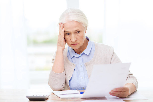 senior woman with papers and calculator at home - Photo, image