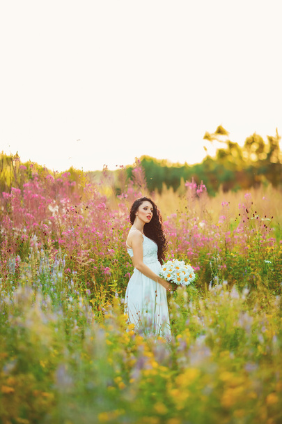 Beautiful young woman in purple flowers outdoors - Fotografie, Obrázek