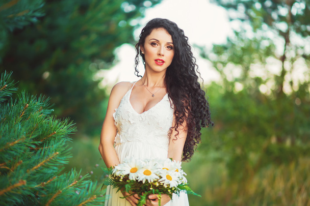 beautiful girl in a white dress bouquet in hands - Фото, изображение