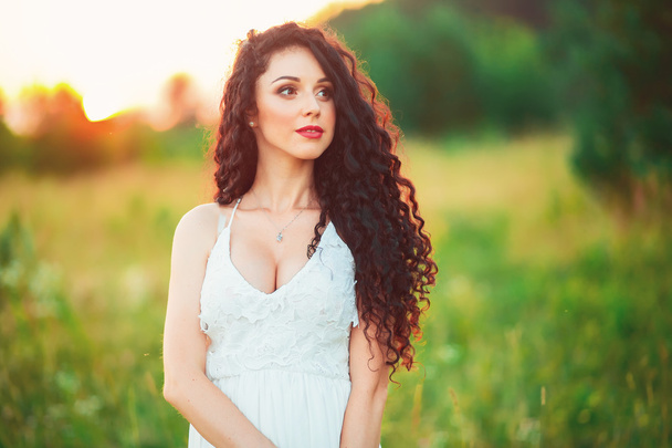 beautiful young girl in a field in white dress has beautiful lon - Foto, Imagem