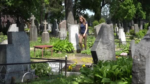 Młoda dziewczyna wizyty kolegów miłośnik człowieka grób na cmentarzu. 4k - Materiał filmowy, wideo