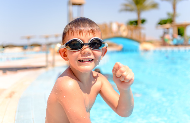 Onnellinen virnuileva nuori poika uima-altaalla
 - Valokuva, kuva