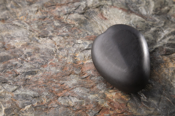 Базальтовое каменное сердце на грубом камне
 - Фото, изображение