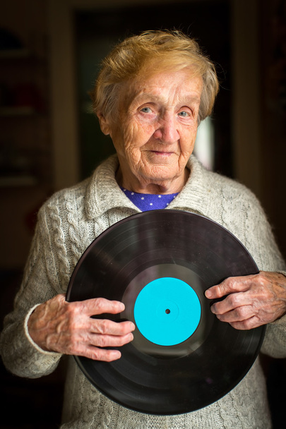 Old woman and vinyl record - Foto, afbeelding