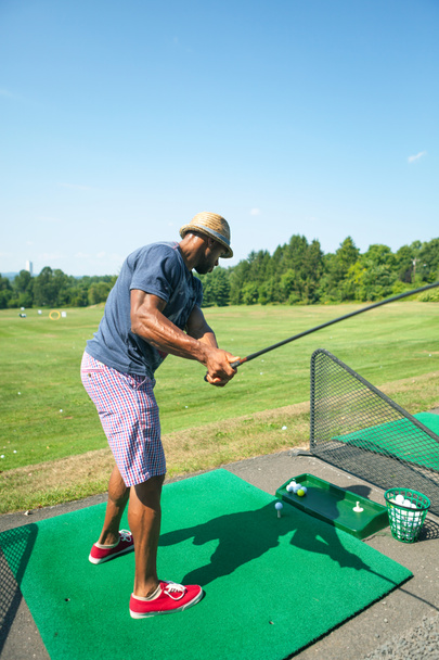 Práctica de golf en el campo de prácticas
 - Foto, Imagen
