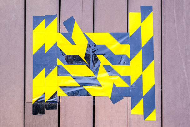 Ruban de mise en garde jaune et noir marqué sur sol en bois cassé
. - Photo, image