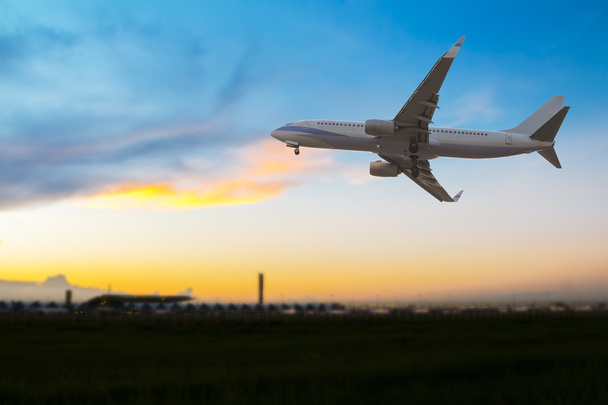 Ticari uçak havaalanında üzerinde günbatımında uçan - Fotoğraf, Görsel