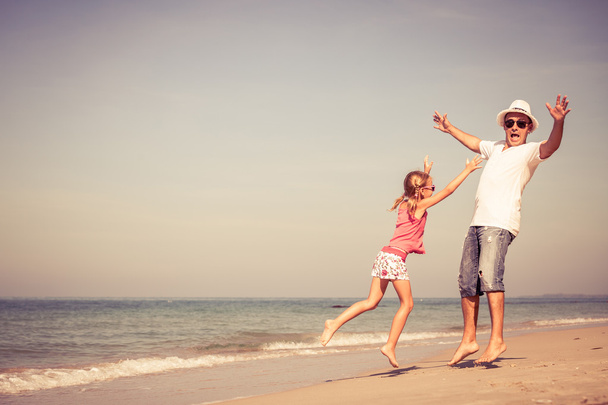 πατέρας και κόρη, παίζοντας στην παραλία κατά τη διάρκεια της ημέρας.  - Φωτογραφία, εικόνα