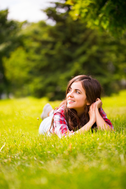 schöne Frau auf grünem Gras liegend - Foto, Bild