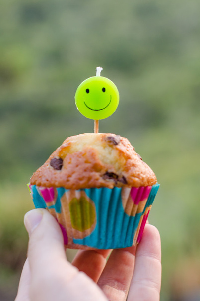 Chocolate chip cupcake and smiley candle. - Photo, Image