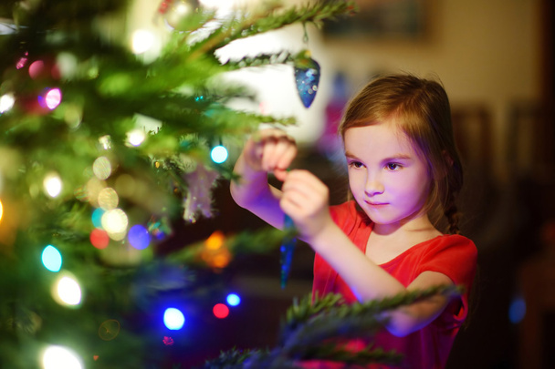 κορίτσι διακόσμησης ενός χριστουγεννιάτικου δέντρου - Φωτογραφία, εικόνα