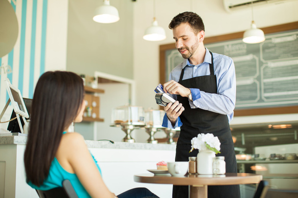 kelner przesuwając karty kredytowej klienta - Zdjęcie, obraz