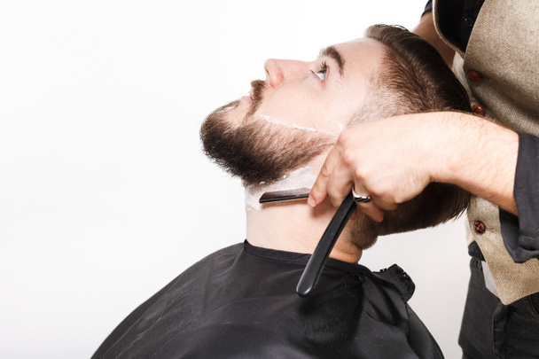 Hairdresser shaving handsome man - Photo, Image
