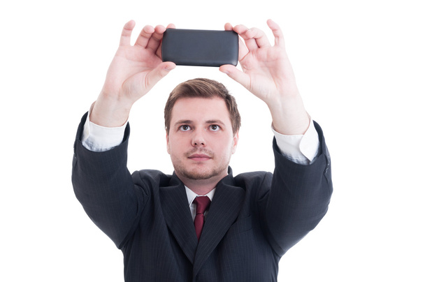 Деловой человек делает селфи с помощью камеры телефона или смартфона
 - Фото, изображение