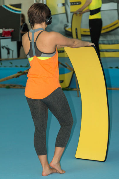 Woman with Headphones and Orange sportswear Doing Fitness Exerci - Photo, Image