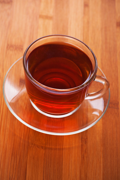 kopje (thee, koffie) tegen houten tafel - Foto, afbeelding