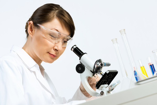 θηλυκός επιστήμονας που ψάχνει στο μικροσκόπιο - Φωτογραφία, εικόνα