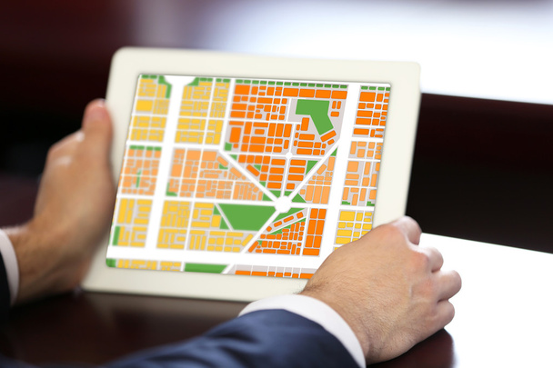 Businessman holding tablet with map gps navigation - Foto, afbeelding