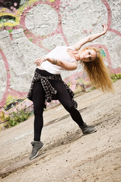 Fiatal lány táncol a graffiti háttér - Fotó, kép