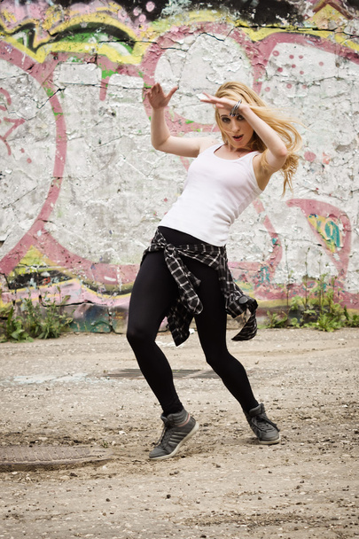 Young girl dancing on graffiti background - Foto, afbeelding