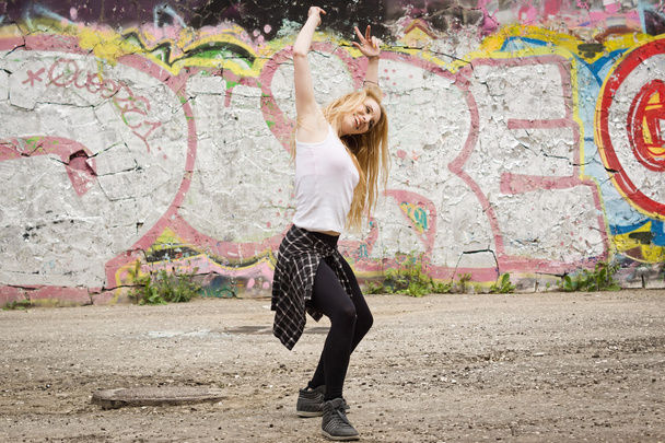 Mladá dívka tančí na graffiti pozadí - Fotografie, Obrázek