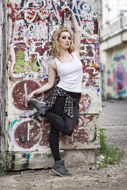 Young woman dancer on graffiti background - Foto, Imagen