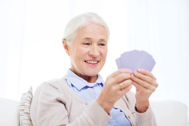 happy senior woman playing cards at home - Foto, Imagem