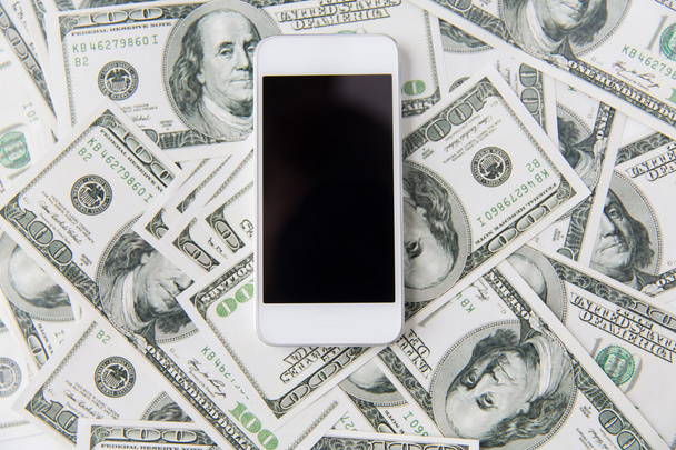 close up of smartphone and dollar money - Foto, afbeelding