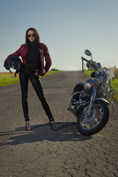 Motorcu kız bir motosiklet üzerinde bir deri ceketli - Fotoğraf, Görsel