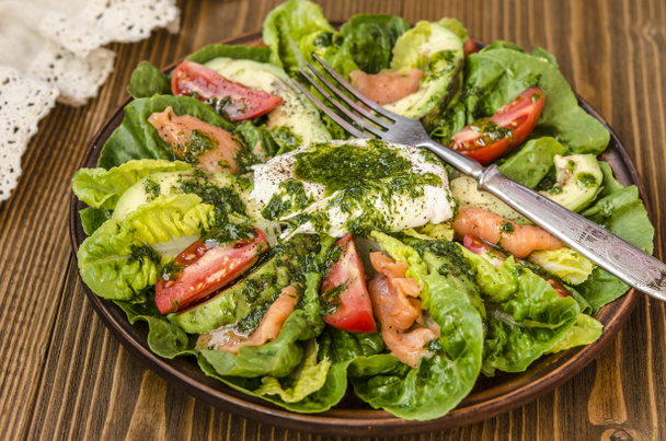Avocado salade met Romano tomaat zalm en gepocheerd ei gekruid - Foto, afbeelding