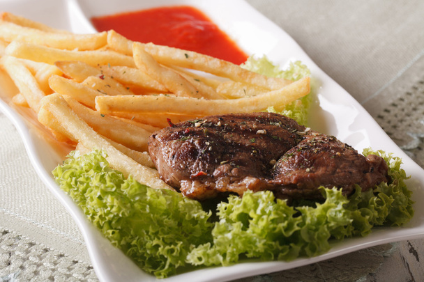 gegrilde biefstuk met Franse frietjes en saus macro. horizontale - Foto, afbeelding