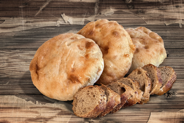 Tranches de pain intégrales Baguette avec pain Pita Mains sur une vieille table en bois
 - Photo, image