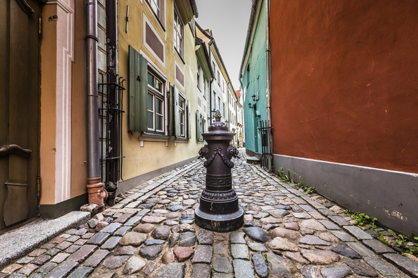 Decorative water column in narrow medieval street of old Riga ci - 写真・画像