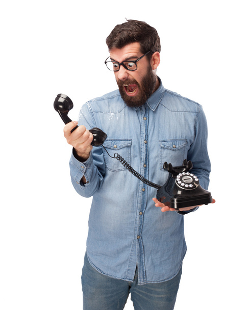 сердитий молодий чоловік з телефоном
 - Фото, зображення