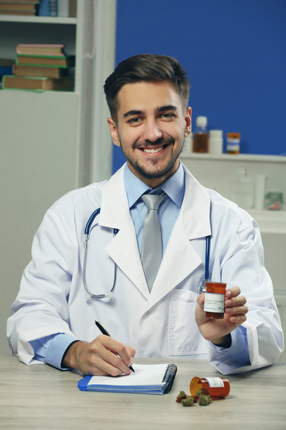Doctor holding bottle with medical cannabis close up - Foto, afbeelding
