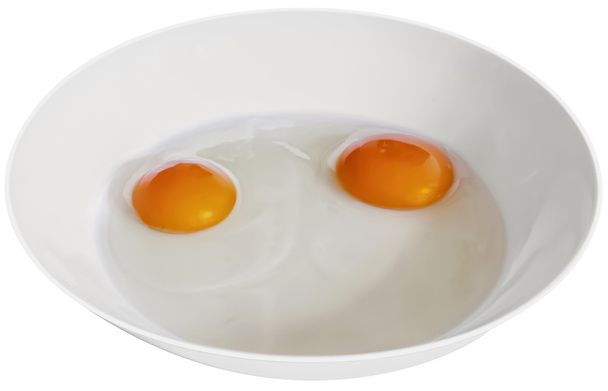 Два яичных желтка в белой фарфоровой пластине изолированы на белом
 - Фото, изображение
