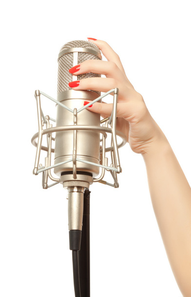 Woman's hand with red nails holding microphone - 写真・画像