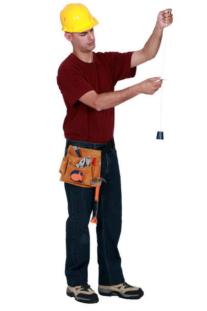 Craftsman holding a string measurement tool - Foto, immagini