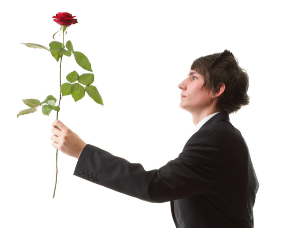 Young man presenting a flower - red rose isolated - Fotó, kép