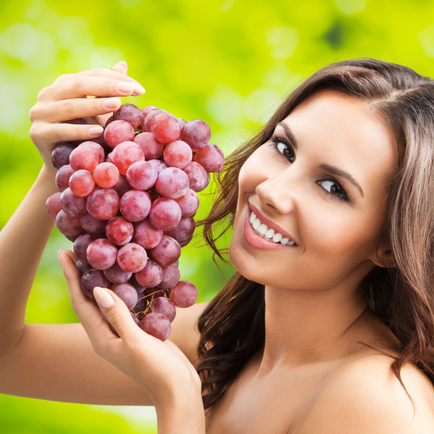 Young happy smiling woman with grapes, outdoors - Foto, Imagen