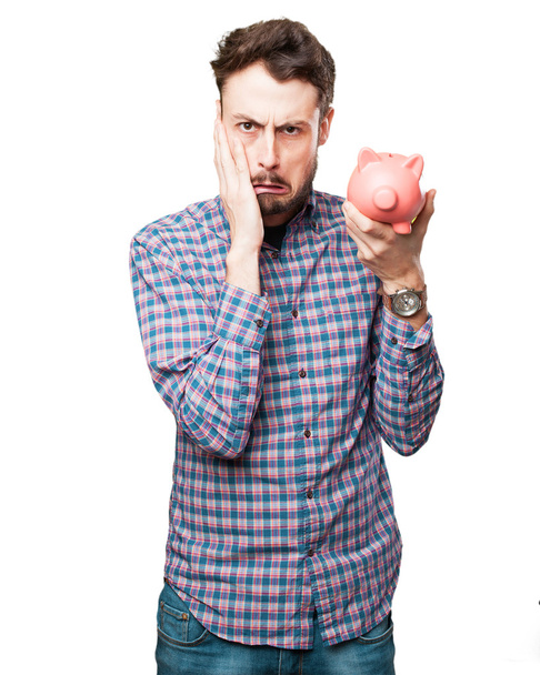 worried young man with piggy bank - Φωτογραφία, εικόνα