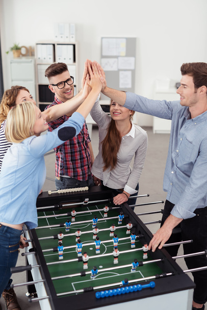 Workmates Putting Hands Together Over Soccer Table - 写真・画像