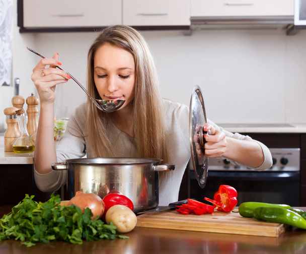 鍋スープをテストとブロンドの女の子 - 写真・画像