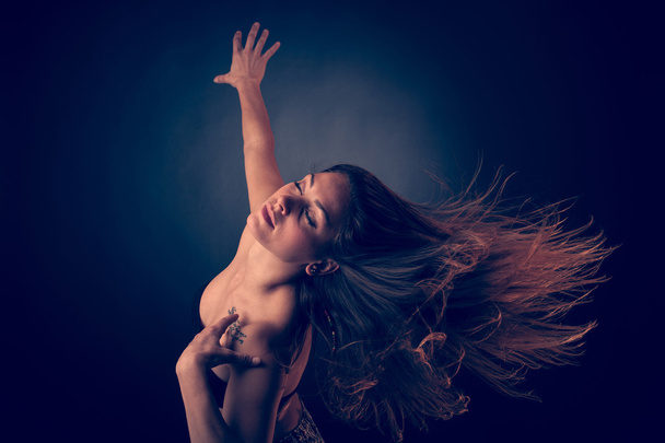 Young brunette caucasian woman dancing and her hair flowing through the air - Φωτογραφία, εικόνα