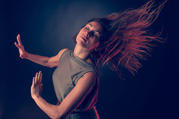 Jovem morena caucasiana dançando e seu cabelo fluindo pelo ar
 - Foto, Imagem
