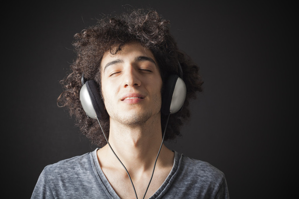 Młody człowiek słuchający muzyki ze słuchawkami - Zdjęcie, obraz