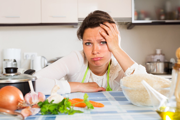 Pensive woman cooks rice with vegetables - Valokuva, kuva