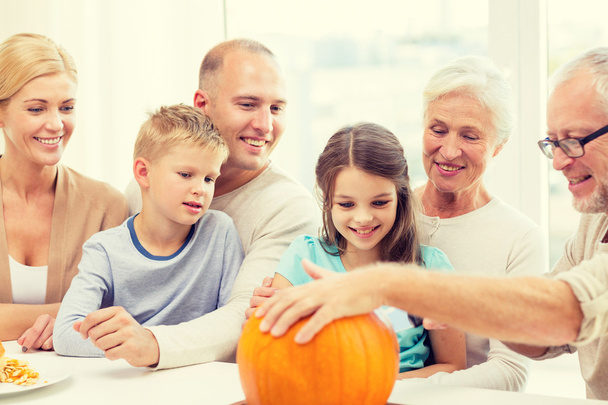 zittend met pumpkins thuis en gelukkige familie - Foto, afbeelding