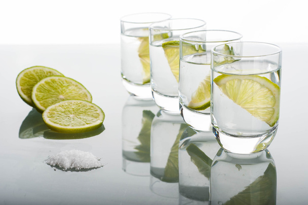 Vier shots van wodka met citroen - Foto, afbeelding